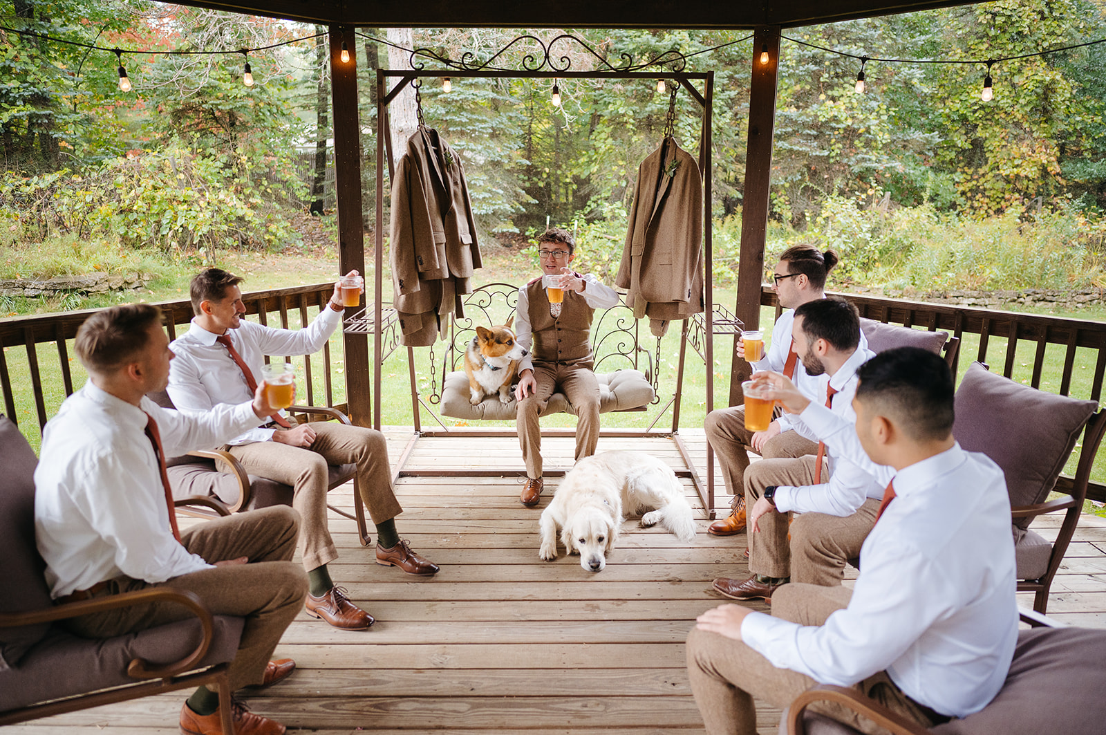 Groom and groomsmen relaxing with two dogs before the wedding