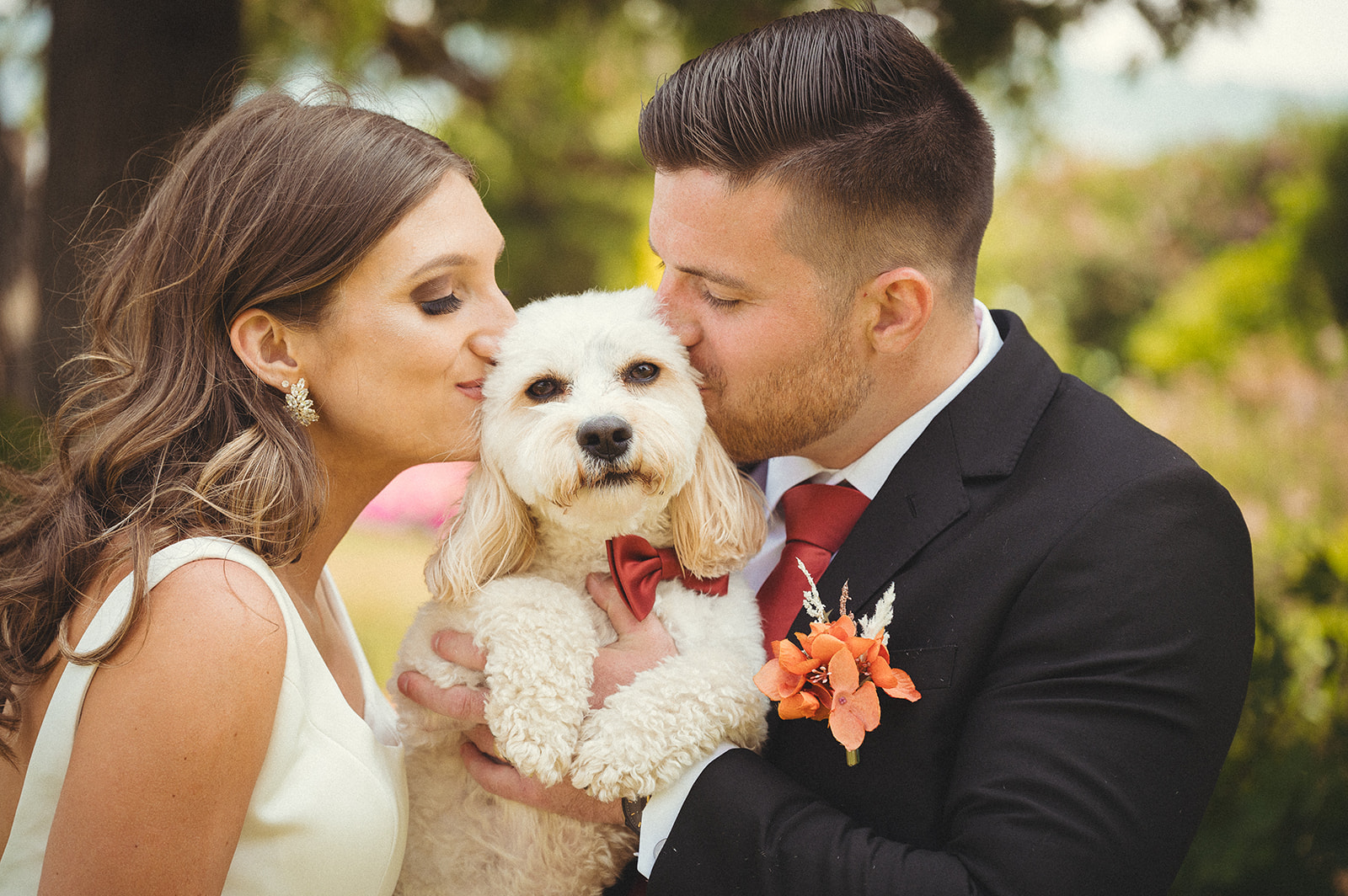 Christina + Garrett Newlyweds kissing their dog on the cheeks